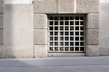 Close up of historical building with retro facade and barred window as concept for being imprisoned prison and being locked upの写真素材