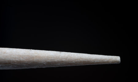 extreme close up macro close up of wood wooden japanese chinese chopstick tip against black background as concept for asian food and chinese restaurantの写真素材