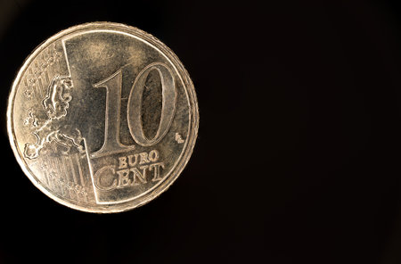 Close up extreme macro of a ten cent cents euro coin against dark black background as concept for euro coins and cashの写真素材