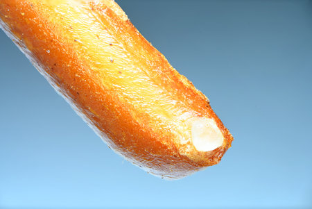 Extreme close up partial view of the top of a salt stick nibble with visible salt crystal against...