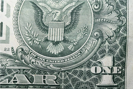 Extreme close up detail of emblem one dollar banknote with clearly visible American eagle laurel branches and arrows with inscription trust as concept for American history money economy and war powerの写真素材