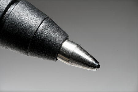 Detail partial view extreme close up of tip of rollerpen pen as concept for signature writing and handwriting against gray backgroundの写真素材