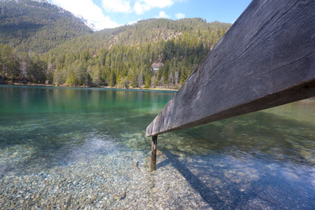 Wide angle shot of intact clear mountain lake in Tyrol with fence leading into water invitation to swim in untouched nature and concept for time out tourism holiday and vacationの写真素材