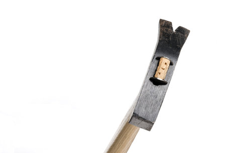 Oblique view of a forged black vintage claw hammer with front for pulling nails and light hickory wooden handle against a white background concept for toolsの写真素材