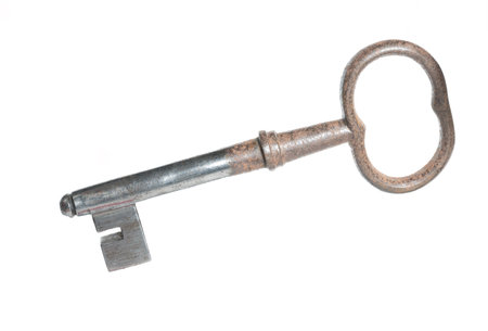 Close-up of an old partially rotten solid simple vintage iron steel metal beard key on a white background as a concept for insecure keys old locking technology and outdated burglary protectionの写真素材