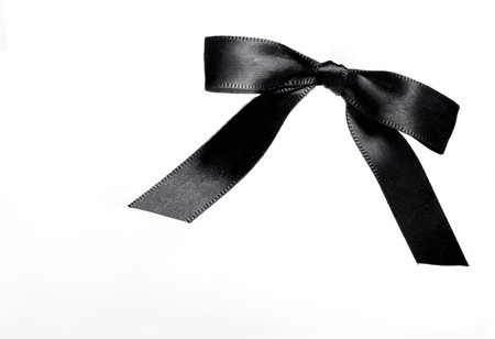 black noble bow loop mesh of black shiny wide ribbon on white background as a concept for mourning loss funeral condolence death commiseration and passing awayの写真素材