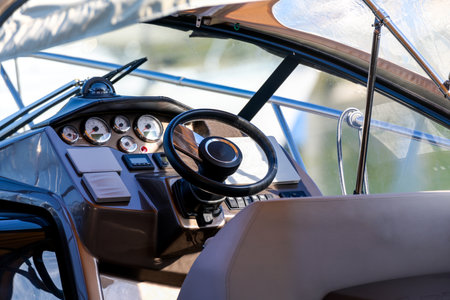 Close up of the driver's cab cockpit of a high quality luxury leisure motor boat with leather steering wheel various switches and buttons as a concept for course keeping steering and decision makingの写真素材