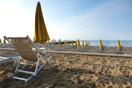 Empty beach morning atmosphere no people sandy beach deckchair sea sunshade against blue sky calm water concept no guests rest vacation lonely island decline tourism sales decrease overnight staysの写真素材