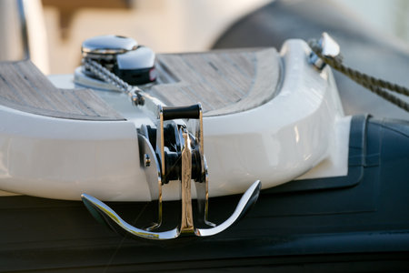 Partial view close up of bow of luxury yacht leisure motor boat with raised metal anchor as concept for safety steadiness reliability and anchorageの写真素材