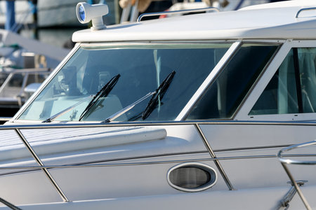 Cab of white luxury leisure motor boat with wipers headlights and windshield as partial view window portholeの写真素材