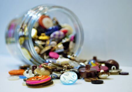 jar full of buttons spilling onto a table