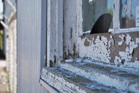 Close up of a dirty broken boarded up window sill on an abandoned buildingの写真素材