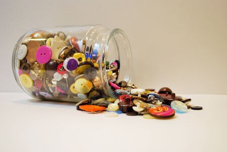 jar full of multi colored buttons overflowing