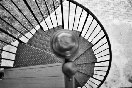 looking down a black and white spiral staircaseの写真素材