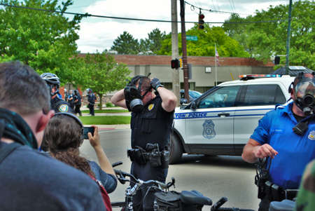 Dayton, Ohio United States 05/30/2020 police officers putting on gas masks preparing to deploy OC...
