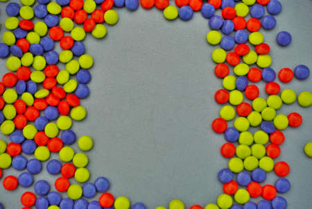 Colorful Halloween candy background orange blue green purple candy coated milk chocolate room for...