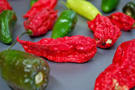 Fresh jalapeno habanero and banana pepper on a silver background