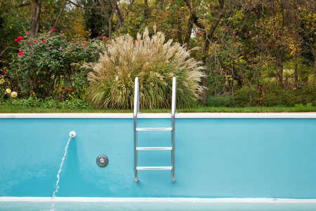 backyard swimming pool with ladder emptied out shutting down for winter