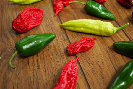 Fresh jalapeno habanero and banana pepper on a wooden background