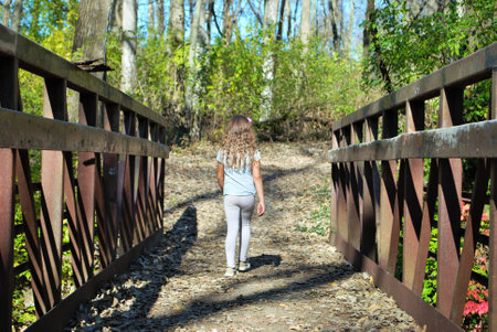 unrecognizable little girl hiking through the woods by herselfの写真素材