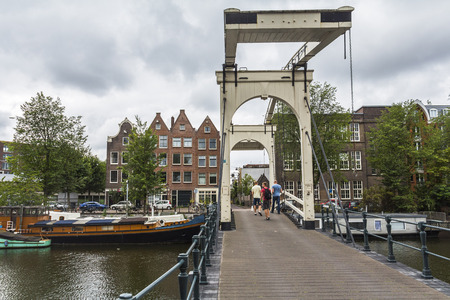 Bridge over typical canal in Amsterdam suburb, Netherlandsの写真素材