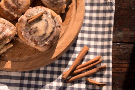 Cinnabon buns with cinnamon on a wooden boardの写真素材