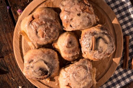 Cinnabon buns with cinnamon on a wooden boardの写真素材