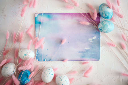 Easter mock up with fluffy flowers, eggs and watercolor abstract painting with space for textの写真素材