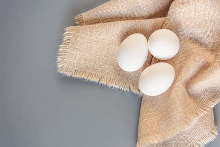 Cardboard egg rack with eggs on gray background. Top view. Rural still life, natural organic healthy food with free spaceの写真素材