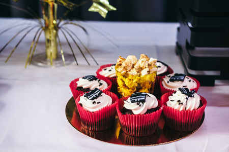 Tasty candy bar with popcorn and muffins in red, black and gold colorsの写真素材
