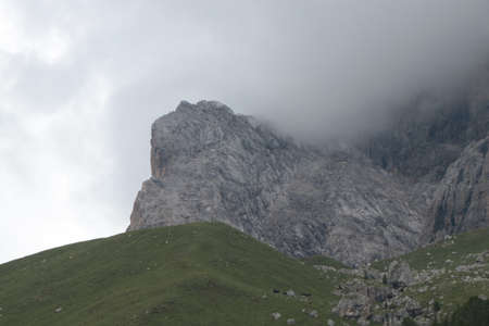 A close up of a rock mountain with cloudsの写真素材