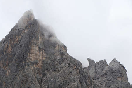 A close up of a rock mountain with cloudsの写真素材