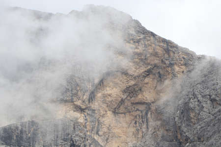 A close up of a rock mountain with cloudsの写真素材
