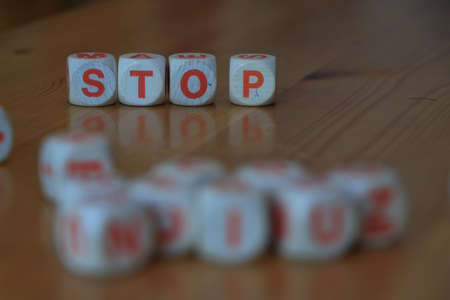 Wooden orange and white letter dice forming the word Stop on wood backgroundの写真素材