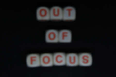 Wooden letters dices forming the writing OUT OF FOCUS on a black background. Written out of focusの写真素材