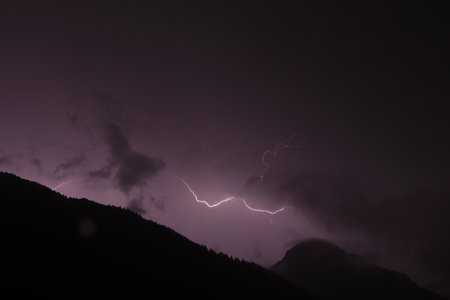 Lightnings in the mountains on a black and purple background. Lighting bolt, lightningの写真素材