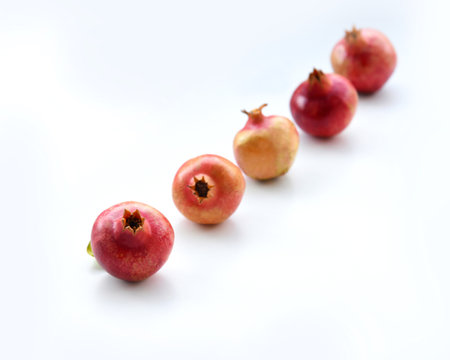 Pomegranates isolated on white background with shadows. Set of whole ripe fruit, red, pinkish, and yellow with clear details and smooth blur. fresh healthy food. Harvest from a garの写真素材