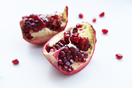 Two halves of juicy ripe pomegranate fruit on a white background close-up. Pomegranate Isolated Whole Pomegranate slices Red Healthy on a white background.の写真素材
