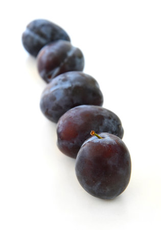 plums isolated on white background with shadows. A set of whole ripe fruits in blue, purple color with clear details and smooth blur. Fresh healthy food.の写真素材