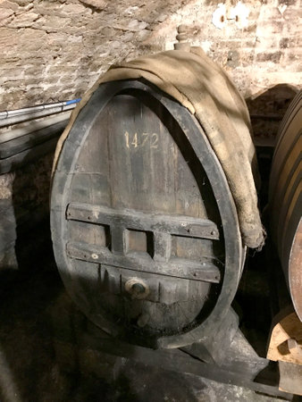 Barrels aging wine in France. Old large barrels of wine in a dark cellar.