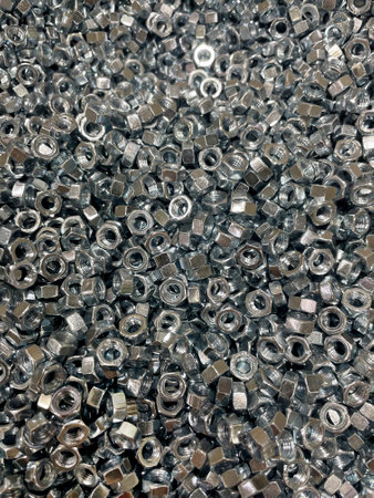 Nuts for bolts. Many new nuts for bolts. Galvanized construction fasteners. Technical texture background. Full frame picture.の写真素材