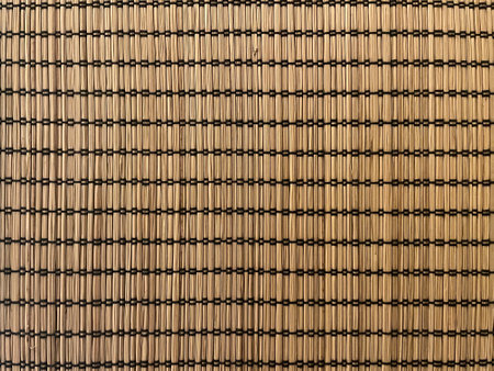 Bamboo mat close up, may be used as background. Wicker wooden napkin background texture.
