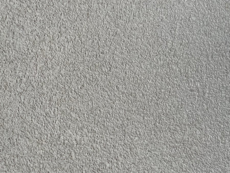 Roughcast surface. Grunge texture as background. Bumpy gray exterior wall with small frequent cracks. Rugged coarse cement or concrete rendering. Painted pebble dash.の写真素材