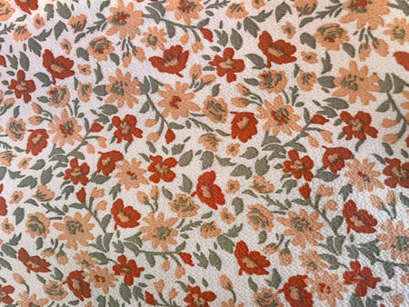 Fabric with a delicate floral pattern, close-up as texture. Old-fashioned cotton or linen textile in a retro style with a print of scattered colorful flowers. Bright floralの写真素材