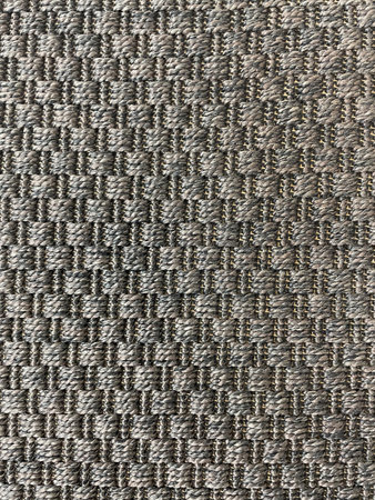 Closeup of woven fabric texture in neutral gray and brown tones. Textile background with braided...