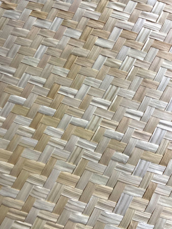 Close-up of natural woven bamboo texture with herringbone pattern. Light beige and cream tones...