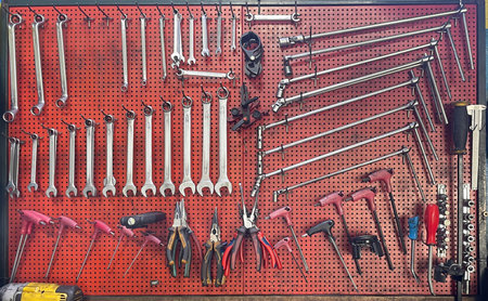 Organized wall of mechanic tools in an auto repair workshop. Wrenches, pliers, screwdrivers and...