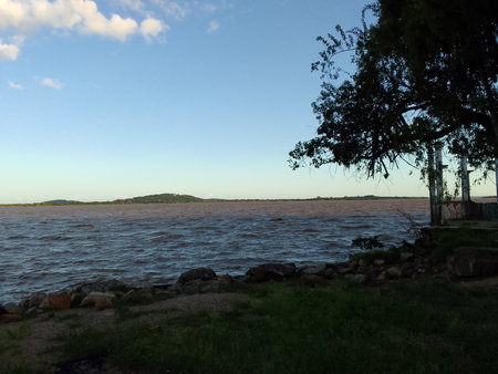The coast of the lake in the evening with trees and blue skyの写真素材