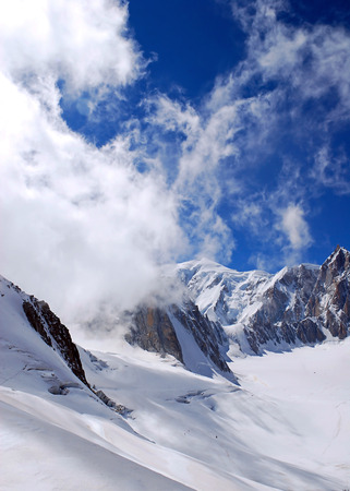 Alps mountains covered in snow against the blue skyの写真素材