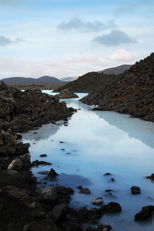 Scenic peaceful view of Iceland's unique natural Blue Lagoon site with black lava rock piles and stones and the ponds of thermal water full of sulfurの写真素材